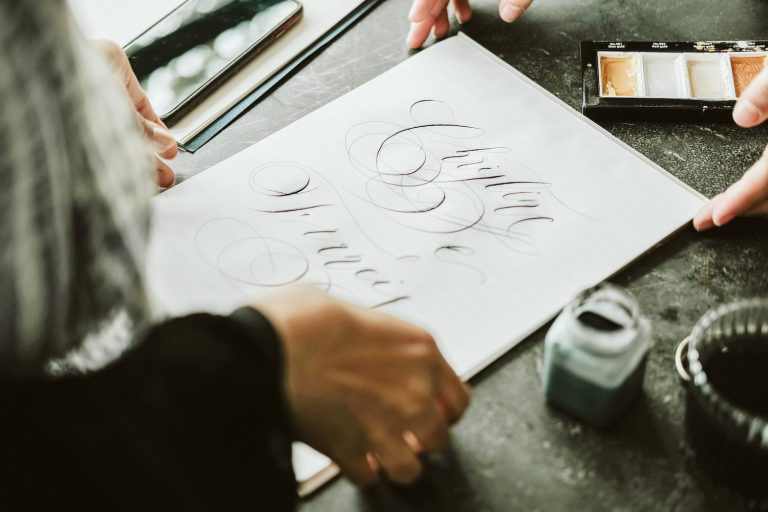 Marketing to wedding planners showing caligraphy designs to a venue owner