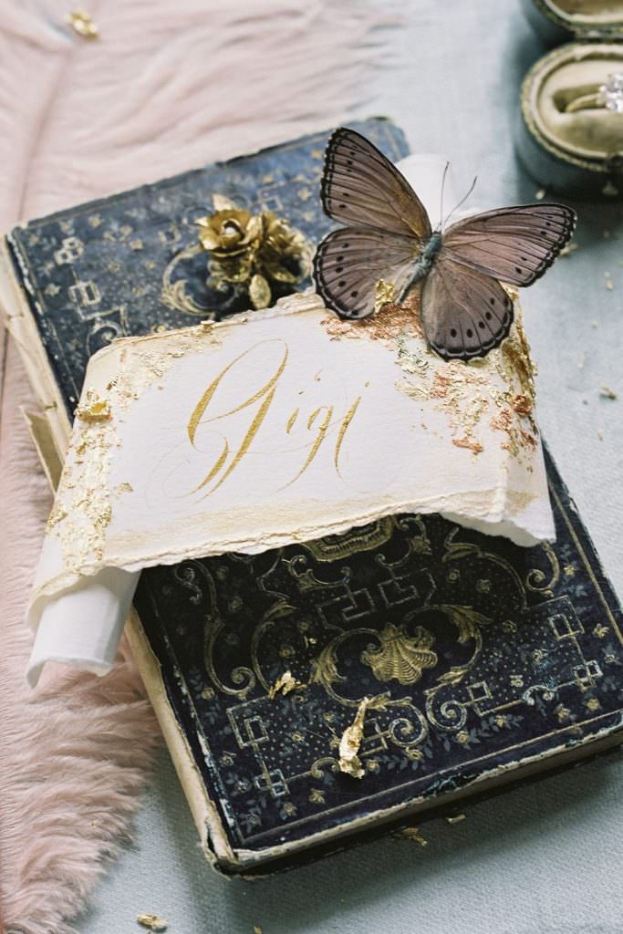 Fine art black tie wedding stationery inspiration with beautifully hand made , scroll place name cards created with gold calligraphy, torn edges and gold foil leaf
