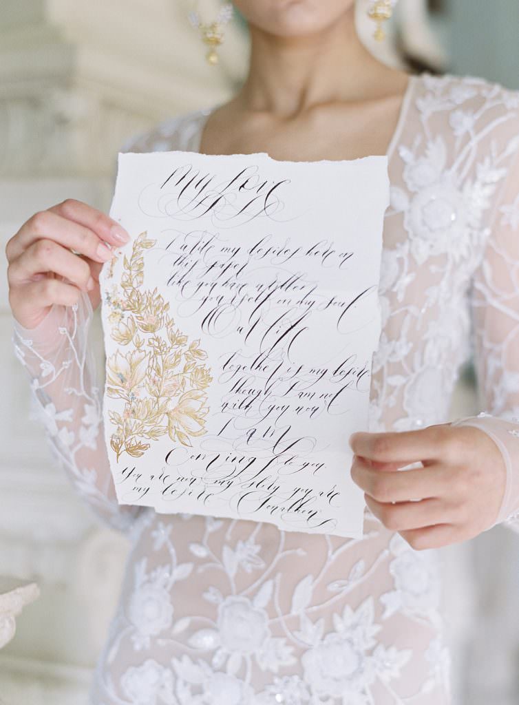 Love letter style wedding vows with black calligraphy and gold botanical flowers