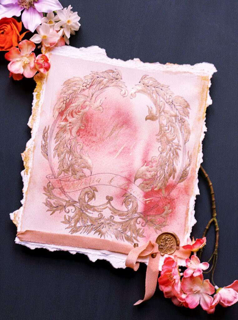Deep dusky pink invitation card with gold filigree design
